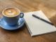 Photo of coffee cup and pad of writing paper with pen
