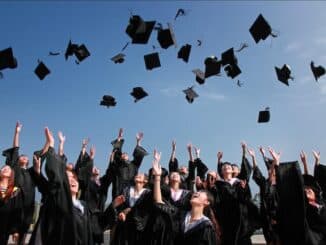 A photo of new school graduates tossing their caps in the air.