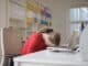 Stock photo of a person resting their head on a laptop keyboard.